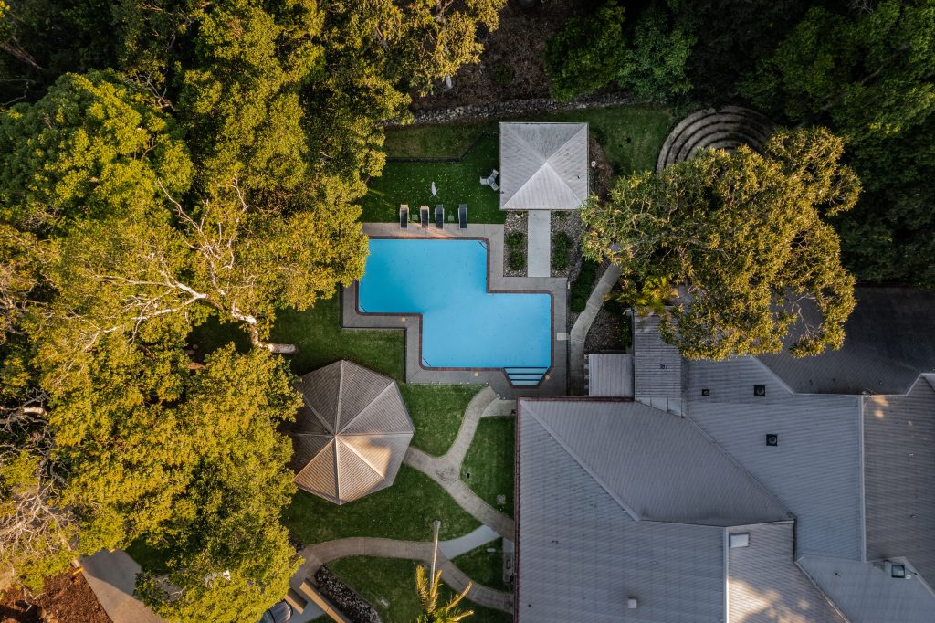A bright outdoor swimming pool surrounded by trees at Invercauld House, a peaceful retreat venue.